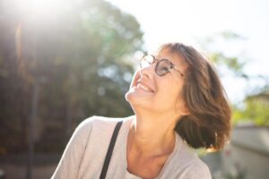 a person smiles in the sunlight after setting recovery goals